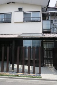 差掛け屋根はシルバー色の板金屋根により薄くて軽い屋根を掛け、屋根下空間は 黒茶色の格子や縦張り杉板外壁 　　により重厚感を演出している